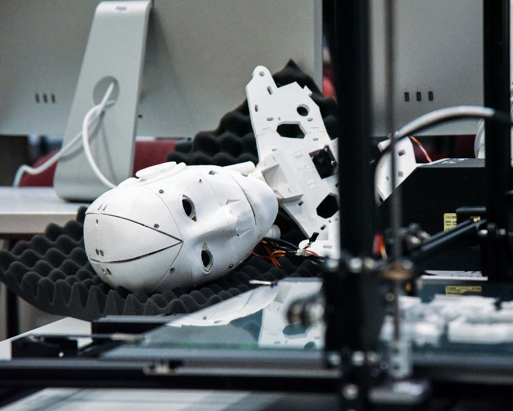 A white plastic robot's head resting on a table, looking out of frame to the right
