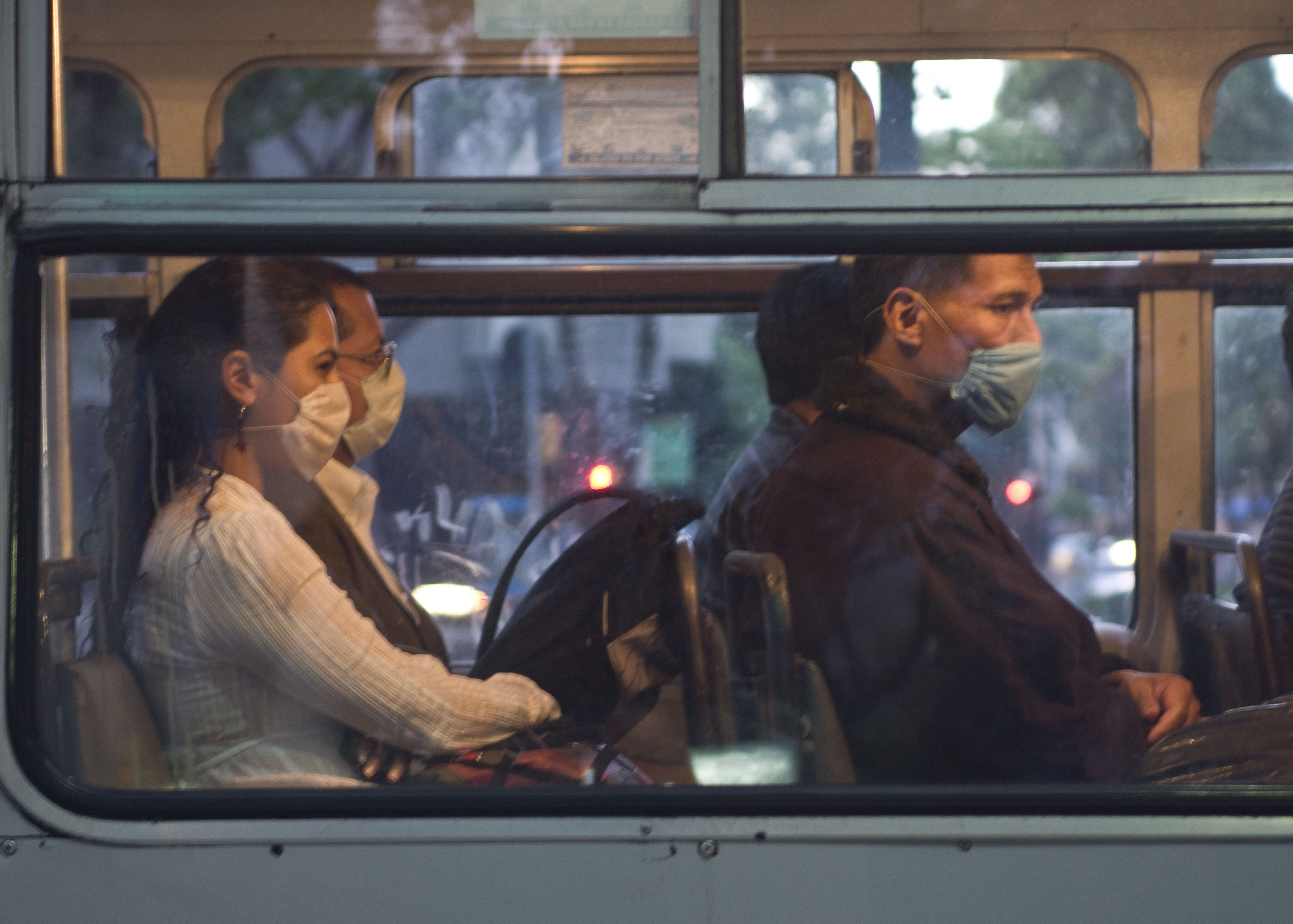 Passengers on a bus wearing surgical masks