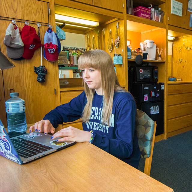 A first-year student at her desk in her room in Anderson Hall. 