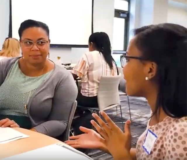 Two staff members talk through an activity in the mentoring matters session