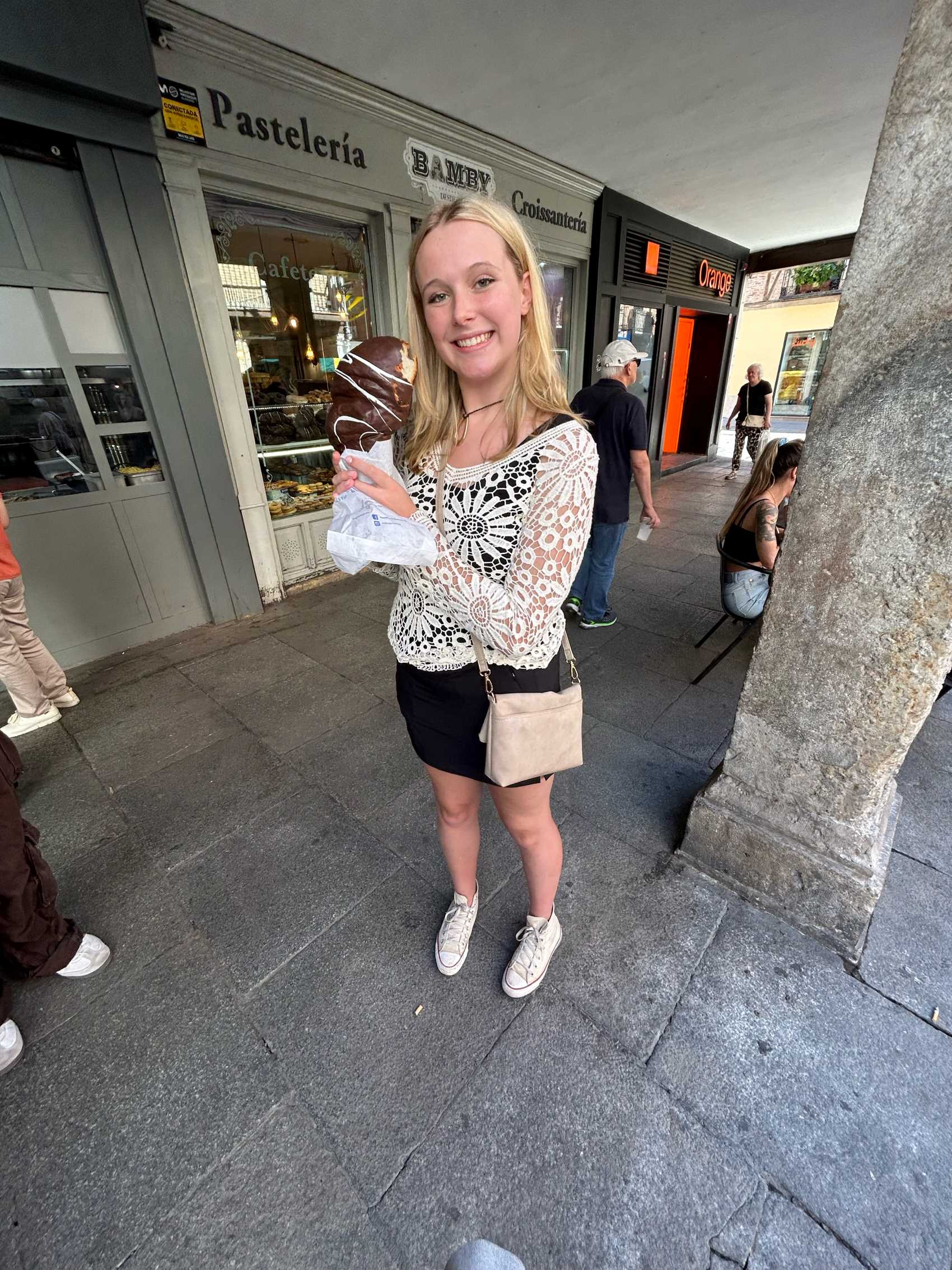 woman holding chocolate croissant