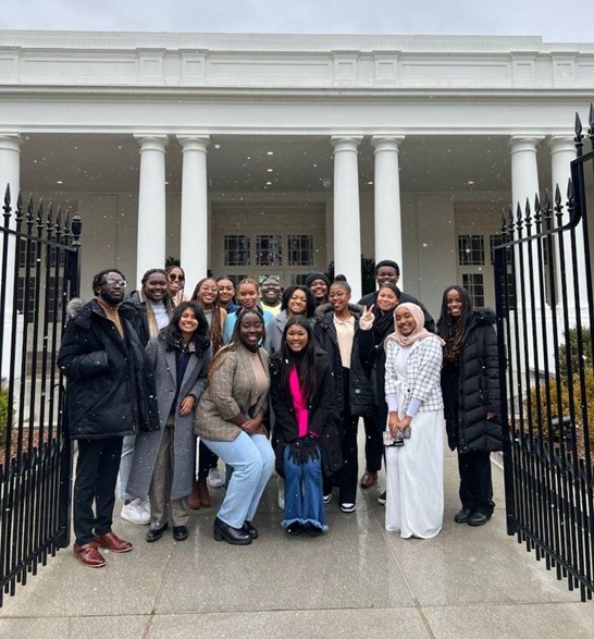 Denia is pictured among members of the Black Student Union (BSU) in front of the White House. There are three rows of students: two in the front, eight in the middle, and seven in the back.