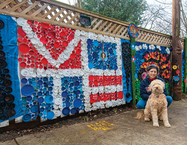 Karen Lash and her dog Lucky in front of her backyard mosaics