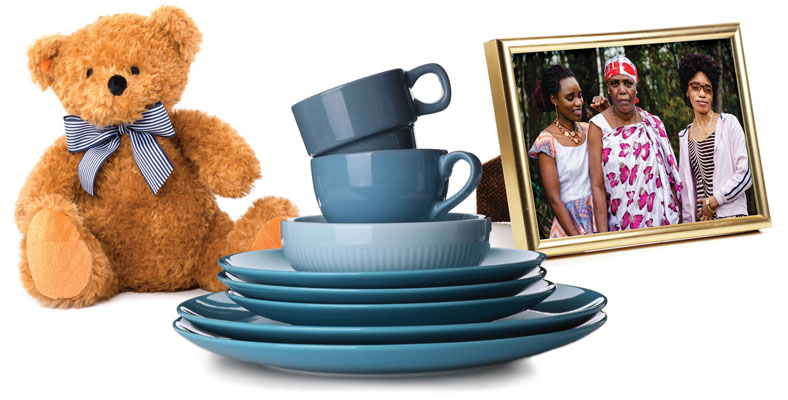 teddy bear stack of blue plates and mugs and photo of three women in gold frame