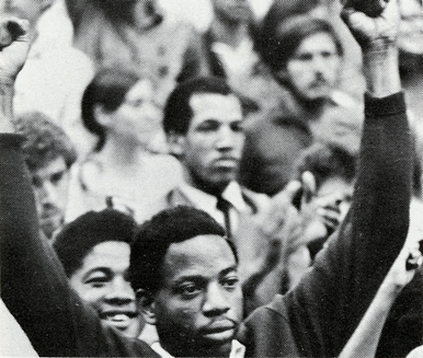 African American student with arms raised at a rally