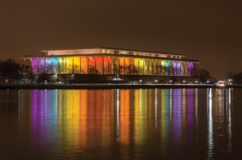 Kennedy Center at night, bathed in rainbow lights