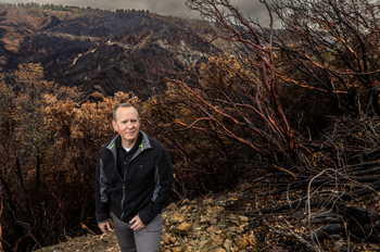 Bob Baird stands at the top of a charred canyon in foresthill california