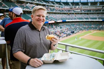 Tim Titus eats a hot dog at a ballpark in Atlanta