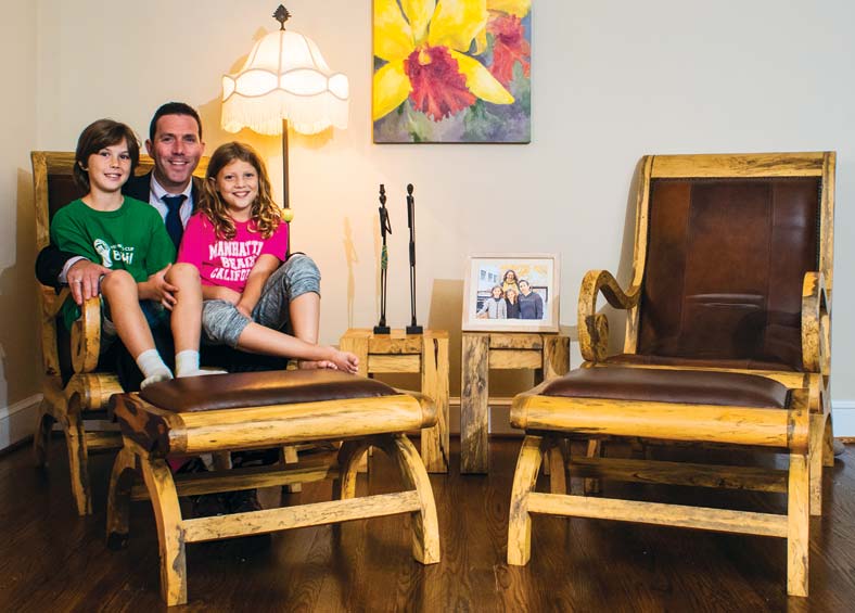 Adam Tomasek and his two young children sit in a chair