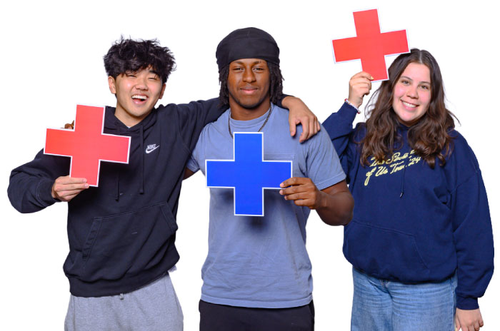 three AU students holding plus signs
