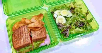 O2GO reusable takeout containers filled with lunch items.