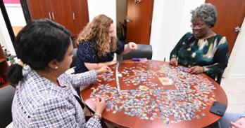 Provost Office colleagues work on a puzzle in Leonard Hall. Photo by Jeff Watts.