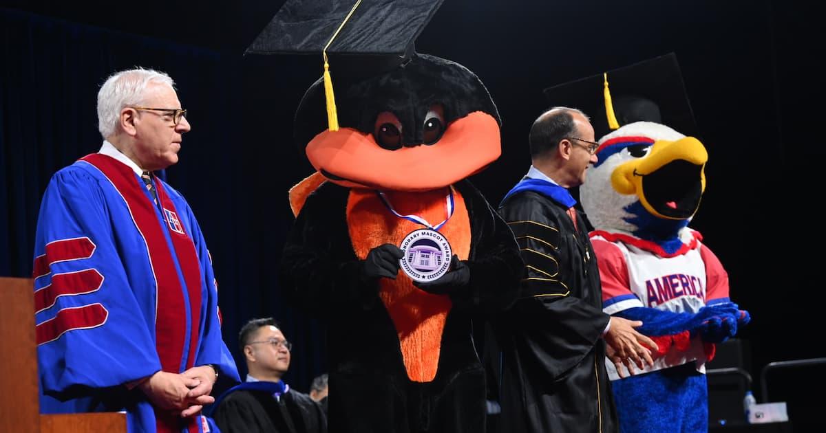 David Rubenstein, right, is joined on stage by the Oriole Bird, Kogod dean David Marchick, and Clawed Z. Eagle. Photo by Jeff Watts.