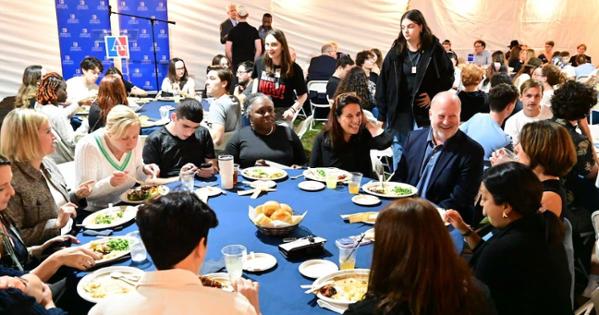 AU community members gather at a table. Photo by Jeff Watts.