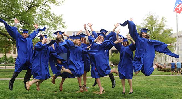 American University graduates leap in celebration on the Quad