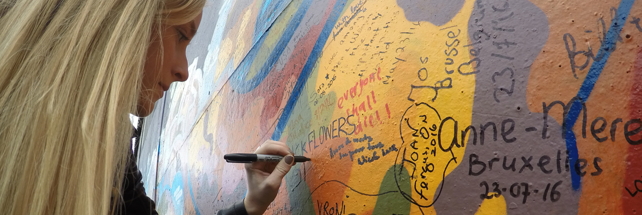 Student signing the Peace Wall in Belfast, Northern Ireland