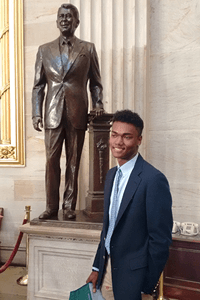 Bobby in front of a statue of Ronald Reagan