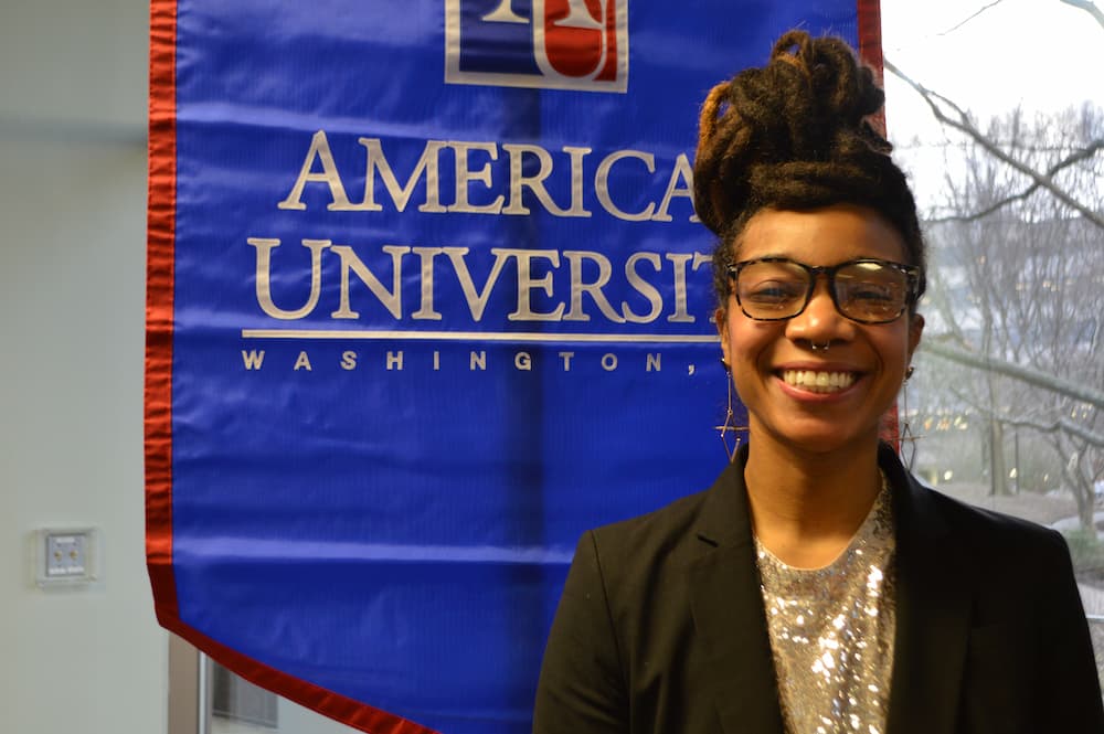 Johneé Rendia Wilson standing in front of AU banner