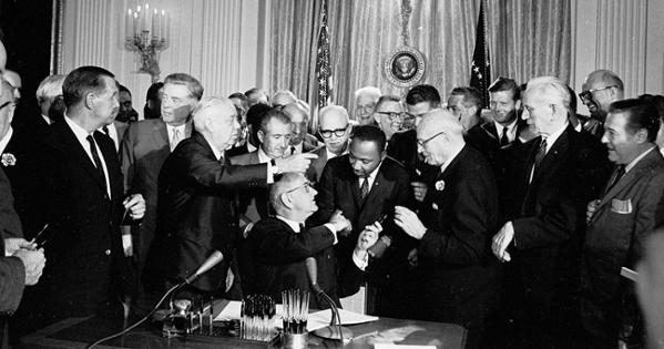 President Lyndon B. Johnson shakes hands with Rev. Dr. Martin Luther King Jr. after signing the Civil Rights Act of 1964. Photo Credit: LBJ Presidential Library