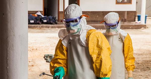 Two people in Ebola personal protective gear in a dry setting