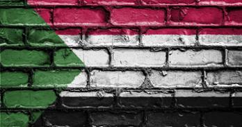 The colors of Sudan's flag is shown on a brick background
