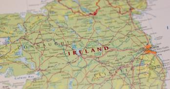 Closeup on a map of Ireland with a red line detailing the border between The Republic of Ireland and Northern Ireland.
