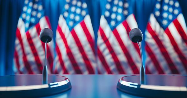 two microphones sit in front of the US flag