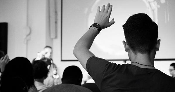 student raising hand in a classroom