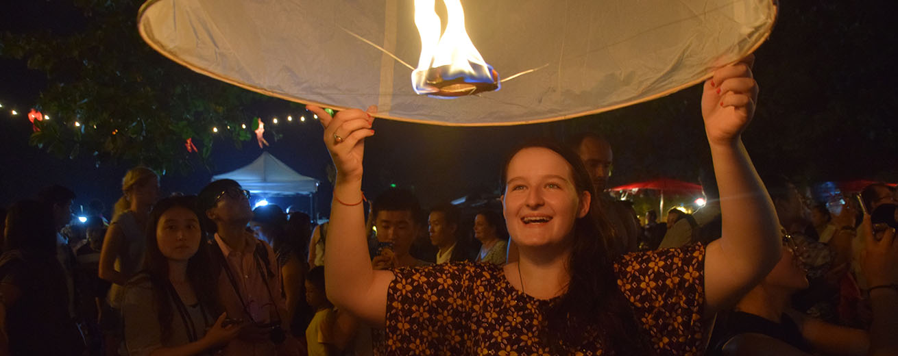 Killian MacDonald holding a lit paper lantern in India.