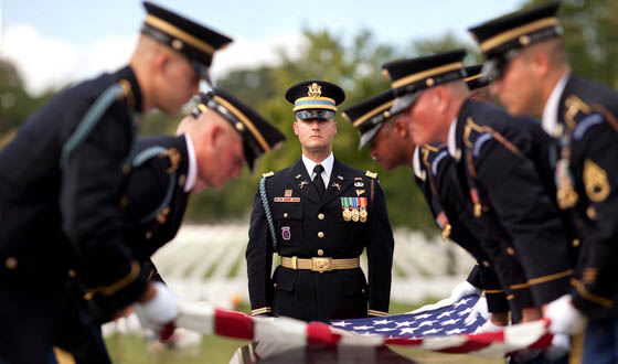 Soldiers folding a flag