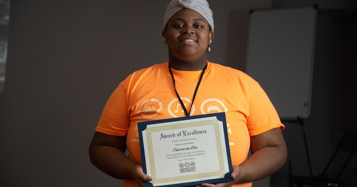 Yanna Contee-Jones holds up an Award of Excellence at AMYF