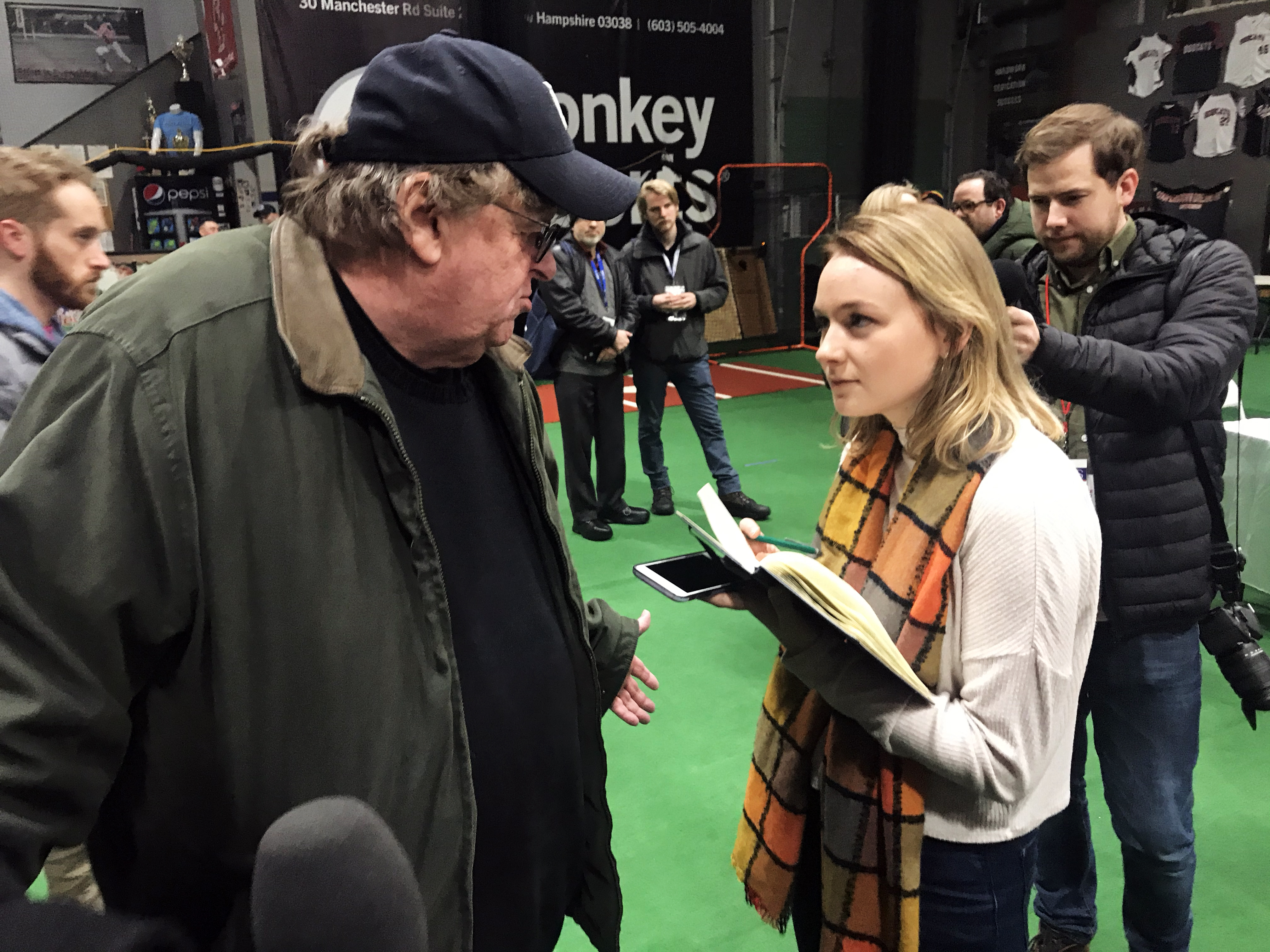 SOC student Karissa Waddick corners filmmaker Michael Moore to ask questions following a Sanders watch party in New Hampshire on Friday.