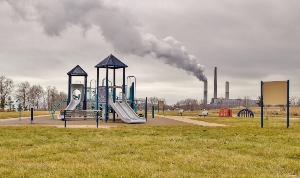 Playground in foreground with smokestacks in the background.