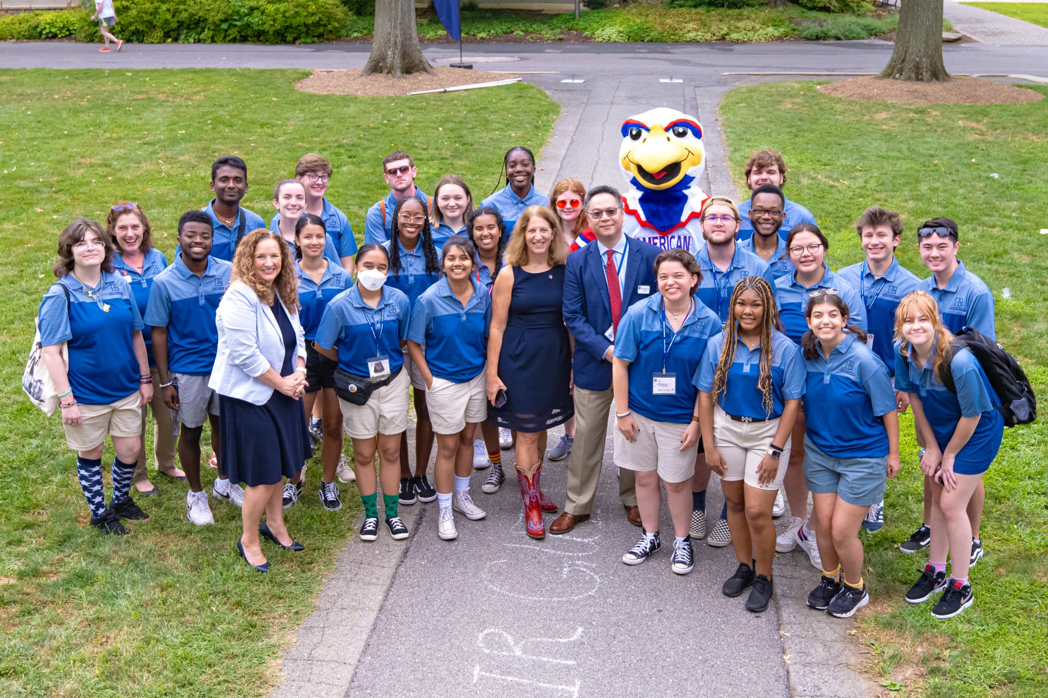 Orientation Leaders pose on the Quad with administrators and Clawed, AU's eagle mascot.