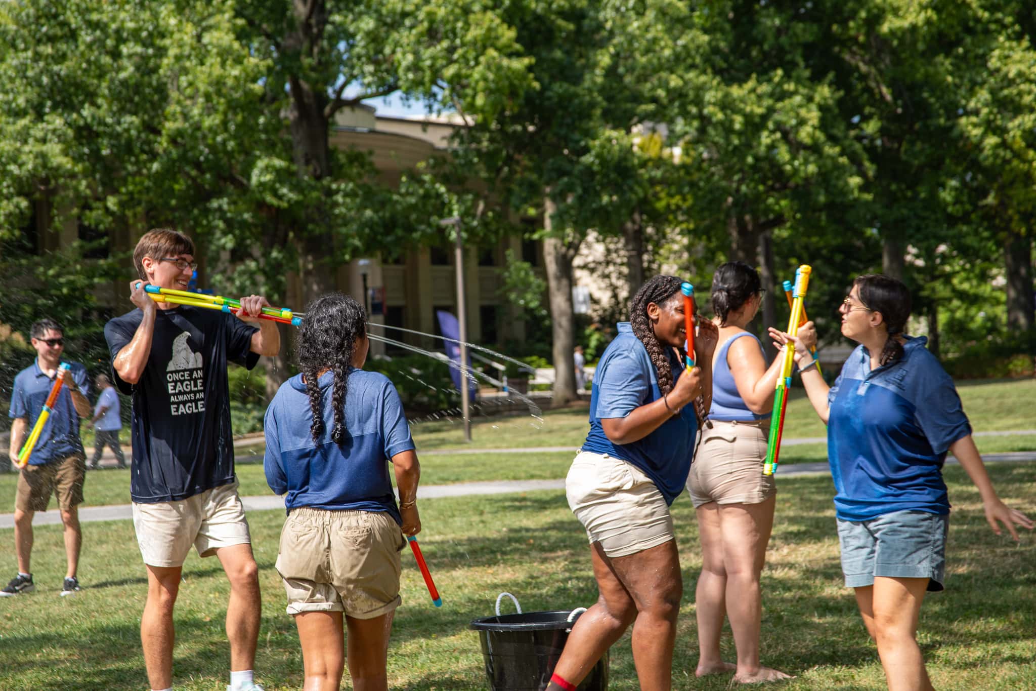 Orientation Leaders playing with water blasters on the quad.