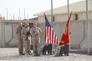 Marines with 2nd Combat Engineer Battalion carry combat boots, a rifle, and Kevlar helmet to build the battlefield cross in honor of three fallen Marines during a memorial ceremony aboard Camp Leatherneck, Afghanistan, July 8, 2014.