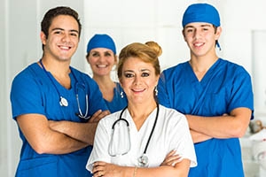 Four healthcare workers wearing scrubs.