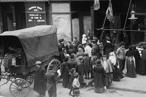 People next to a wagon, in front of a butcher shop.