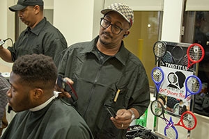 Student getting a haircut in barber chair.