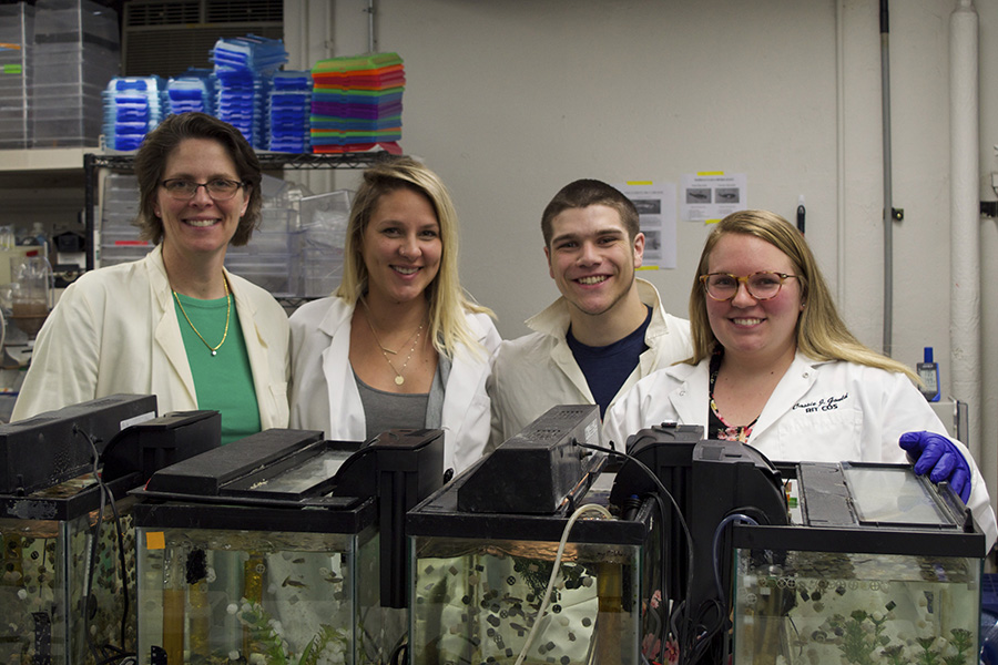 Dr. Connaughton stands with students in the Zebrafish Ecotoxicology, Neuropharmacology and Vision Lab.